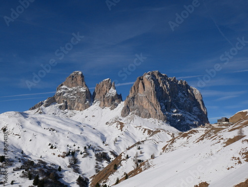 Sella Pass, Selva Val Gardena, Bozen,Trentino Alto Adige, Italy: view of snow covered Mount Sassolungo and Mount Sassopiatto, Dolomites, against clear blue sky, from Sella Mountain Pass photo