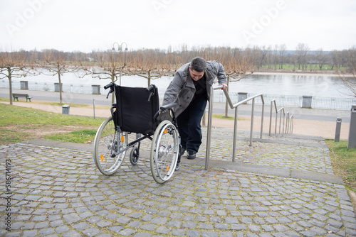 Fotografie a physically disabled person in a wheelchair trying to go down the stairs