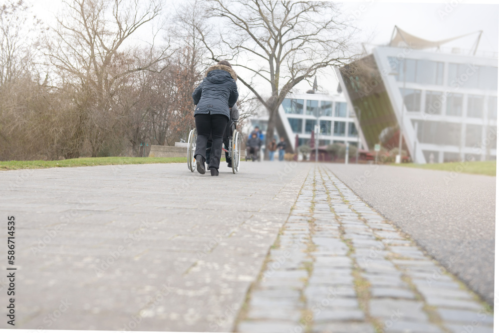 a physically disabled person on a wheelchair at a walk. a physically disabled person on a wheelchair at a walk.