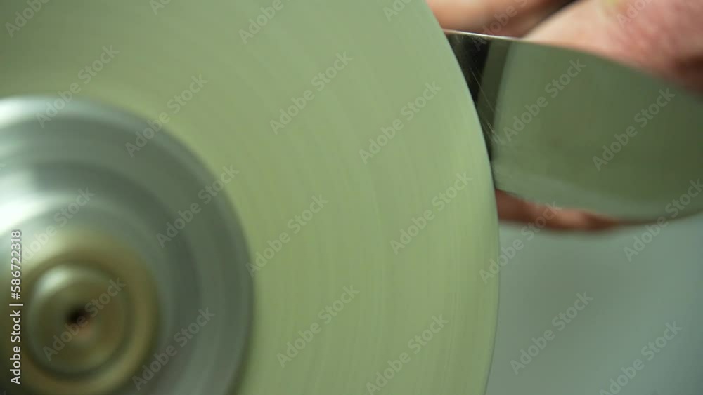 Close-up of sharpening a knife via spinning grindstone