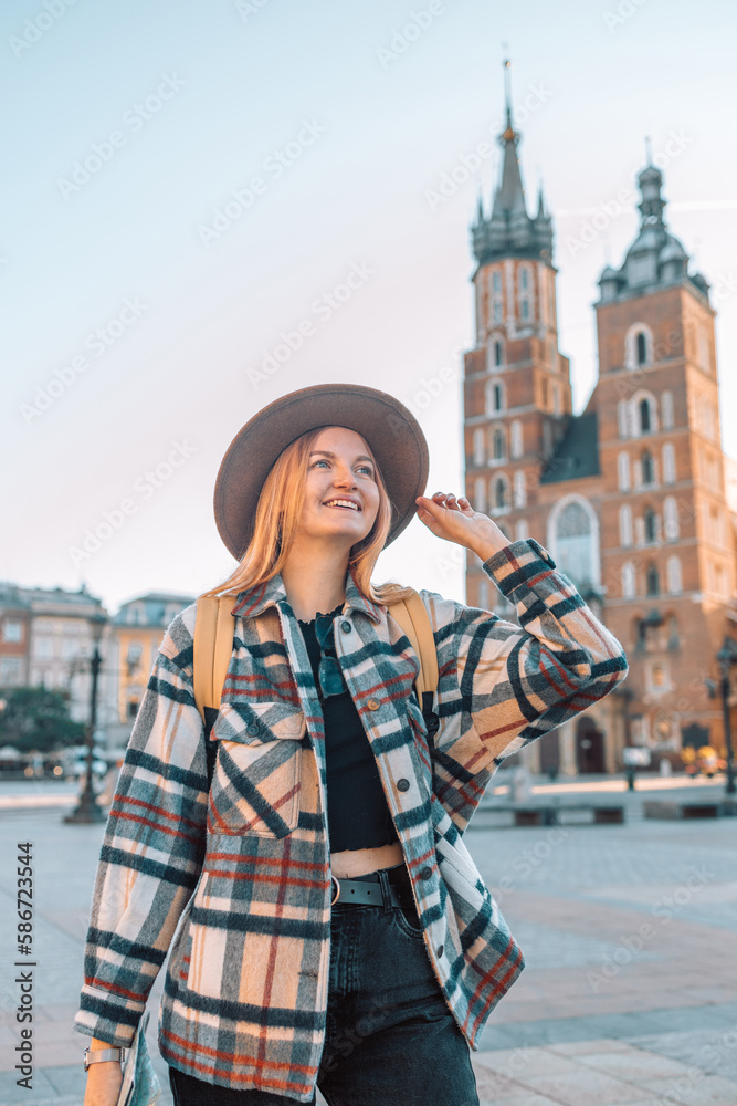 Traveler smiling exploring tourist woman in casual clothes hat hold paper map on Market Square in Krakow. Passenger travel 
