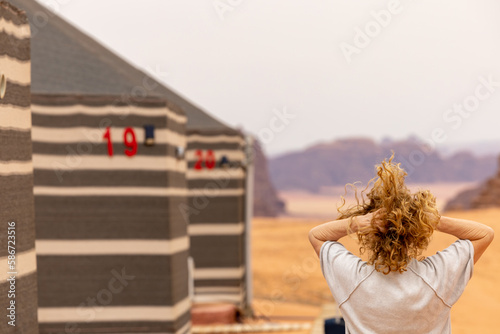 Wadi Rum Jordan A blonde woman checks into a desert cam accommodation.  photo