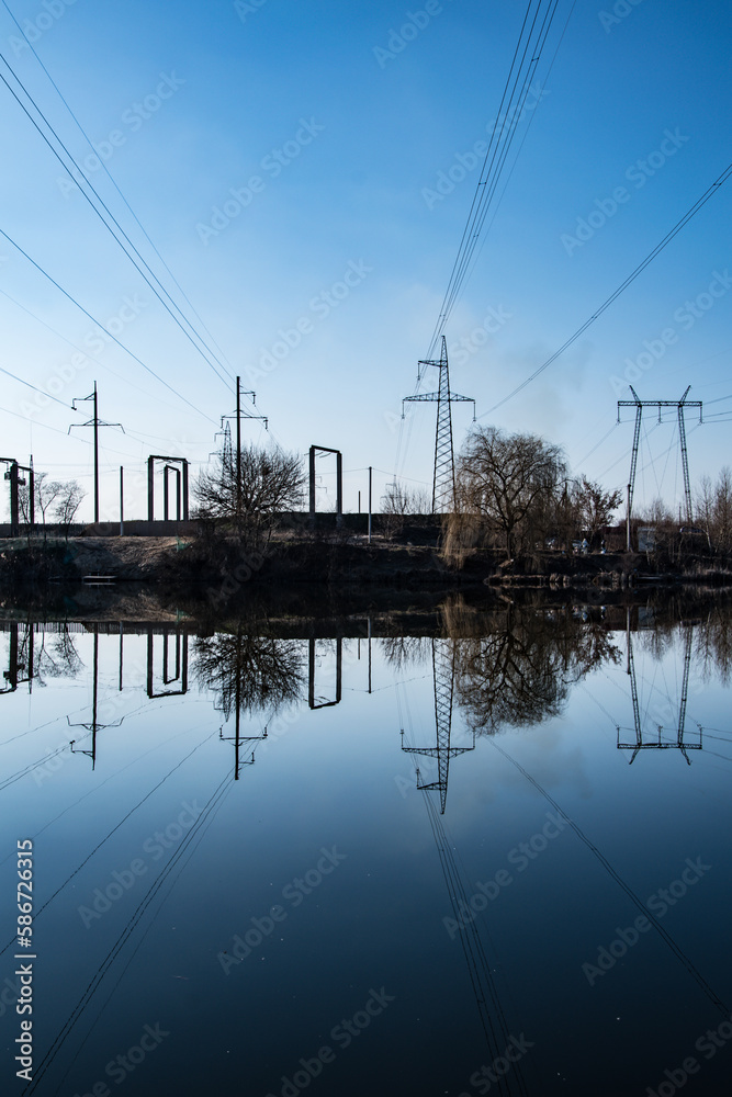 Mirror image of high-voltage power lines in a dark lake