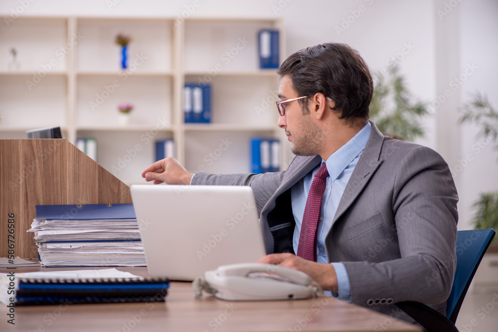 Young male employee working in the office Young male employee working in the office