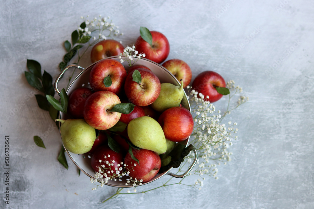 Shiny red apples in white colander. Close up photo of organic fruit on a table. Vibrant colors of seasonal fruit. Eating fresh concept. Bright grey background with copy space. Shiny red apples in white colander. Close up photo of organic fruit on a table. Vibrant colors of seasonal fruit. Eating fresh concept. Bright grey background with copy space.
