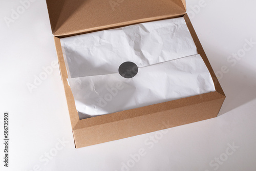 Open gift box on white background, view from above minimalist tissue wrapping gift