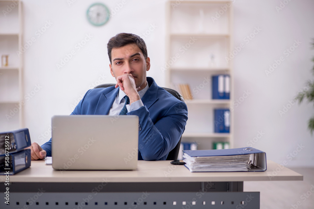 Young male employee working in the office Young male employee working in the office