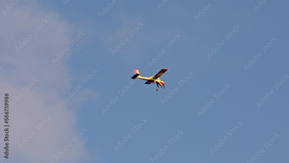 small civil aircraft in sky. Double seat plane flies forward in cloudy sky. agricultural air vehicle carrying employee or business owner flies to work.