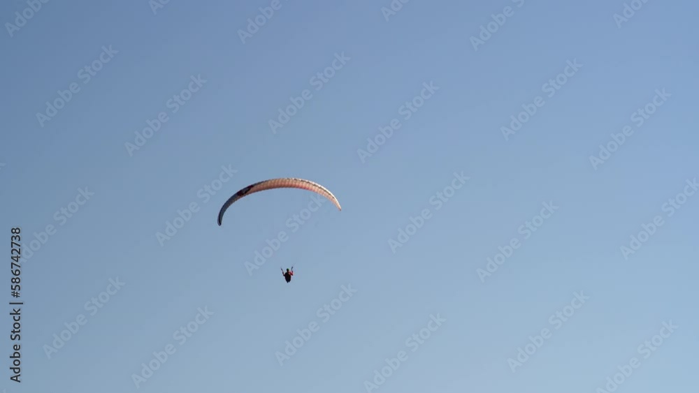 Single paraglider flying against the blue sky. Extreme sports - paragliding in the sky Single paraglider flying against the blue sky. Extreme sports - paragliding in the sky