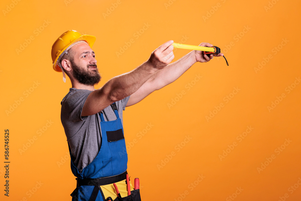 confident-construction-worker-using-tape-measure-to-take-measurements