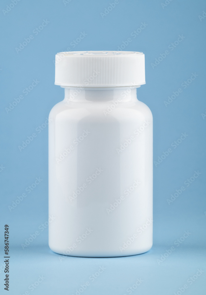 White medical container of pills on light blue background. Drugs and health supplement pills into medicine white bottle health care and medical top view on colored blue background. White medical container of pills on light blue background. Drugs and health supplement pills into medicine white bottle health care and medical top view on colored blue background.