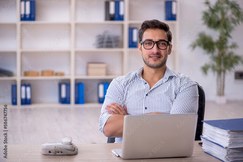 Young male employee working in the office Young male employee working in the office