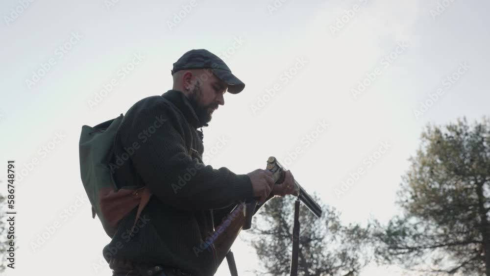 Hunter man discharges the bullets from his gun while hunting outdoors. Hunter man discharges the bullets from his gun while hunting outdoors.