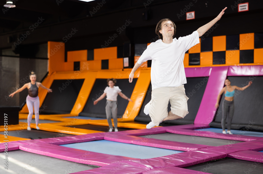 Young sports guy training to do jumps in trampoline center Stock Photo |  Adobe Stock