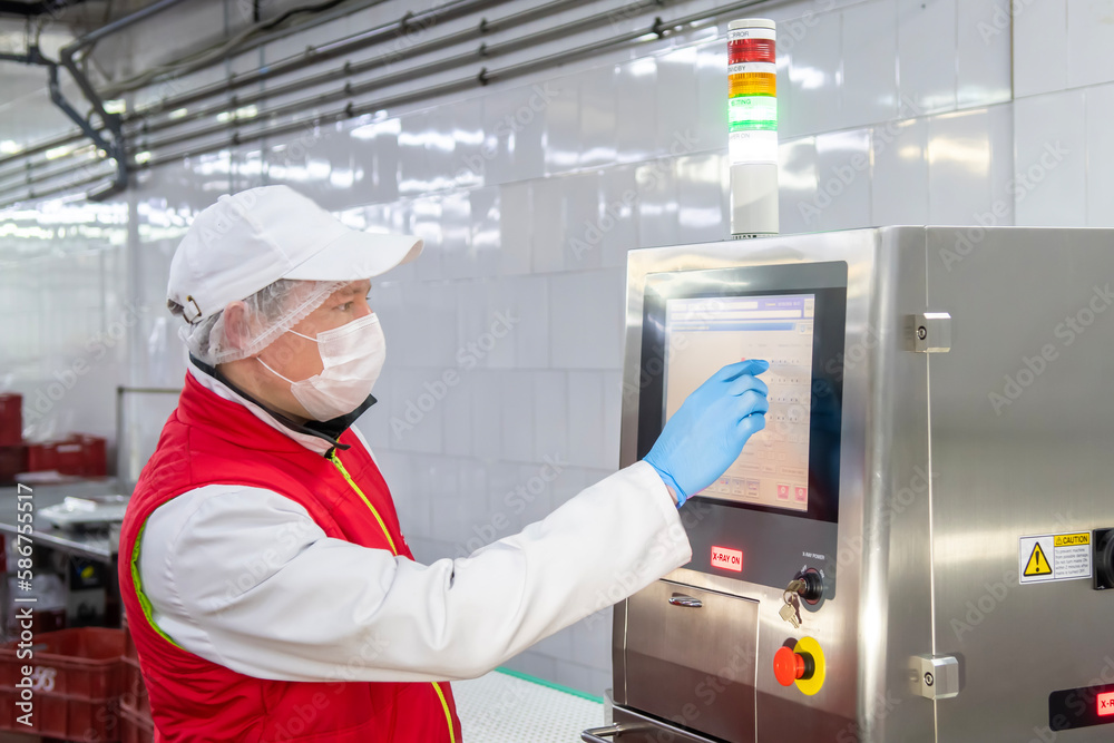 A man are working in sausage factory and he shows how works scan machine  