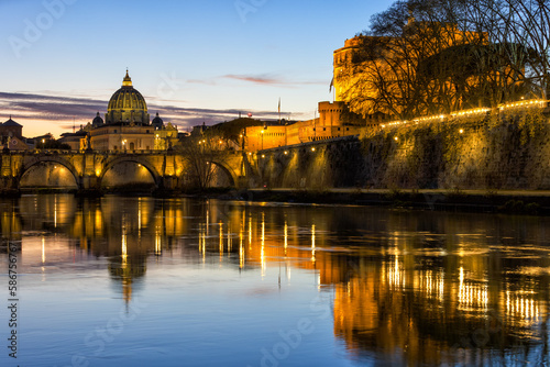 Amazing day to night sunset of Rome, Italy, with the Ponte Sant'Angelo, the Tiber River with reflections on the water, the St. Peter's Basilica in the Vatican and Castel Sant'Angelo