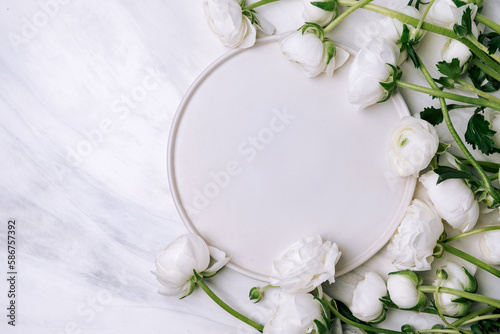 Spring romantic table setting with white plate and  white flowers ranunculus. Easter food background. Flat lay.