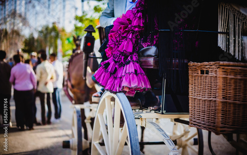 traditional fair in andalusia spain with woman on top of a car pushed by horses photo