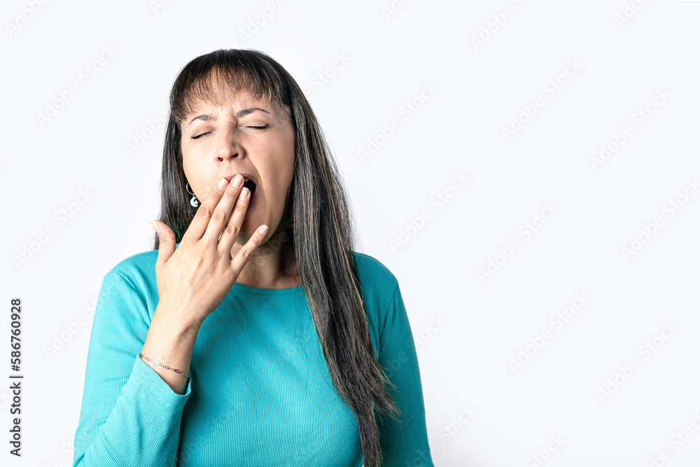 Young woman yawning and covering her mouth with her hand on white background Young woman yawning and covering her mouth with her hand on white background