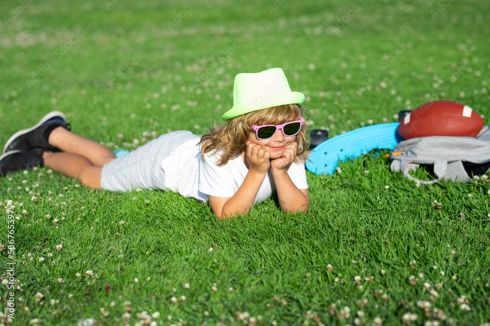 Child on nature. Cute kid boy laying on meadow. Happy child playing in summer park. Child on nature. Cute kid boy laying on meadow. Happy child playing in summer park.
