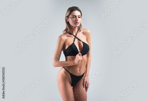 Sexy body of ingerie model in sexy bra and panties. Lace black lingerie. Breast in sexy bra, natural boobs. Sensual model in sexy lingerie isolated on gray studio bachground.