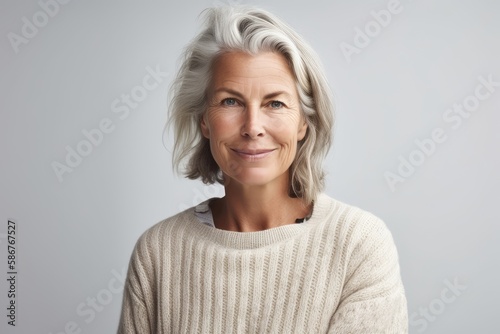 Serenity and confidence: Mature woman in white sweater smiling on white background. Generative AI