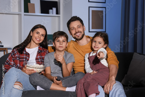 Family watching TV at home in evening