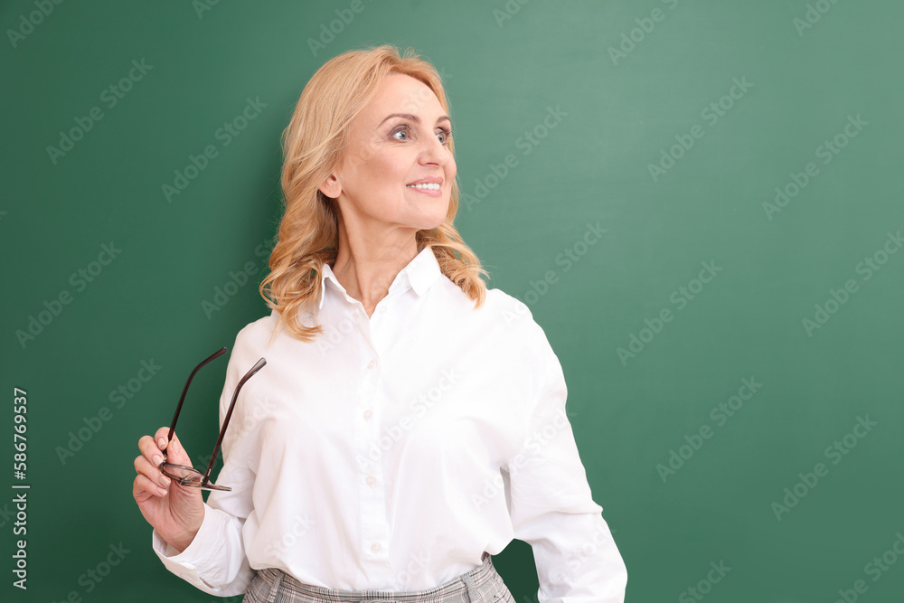 Happy professor with glasses near green board, space for text