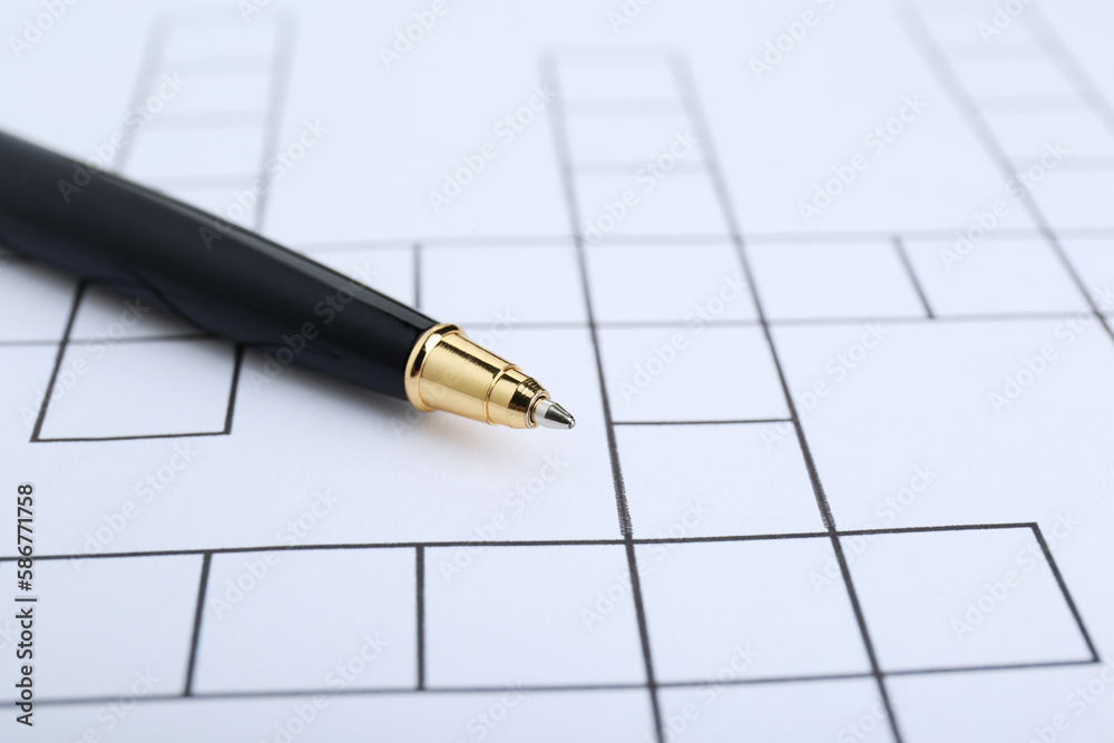 Pen and blank crossword, closeup. Space for text Pen and blank crossword, closeup. Space for text