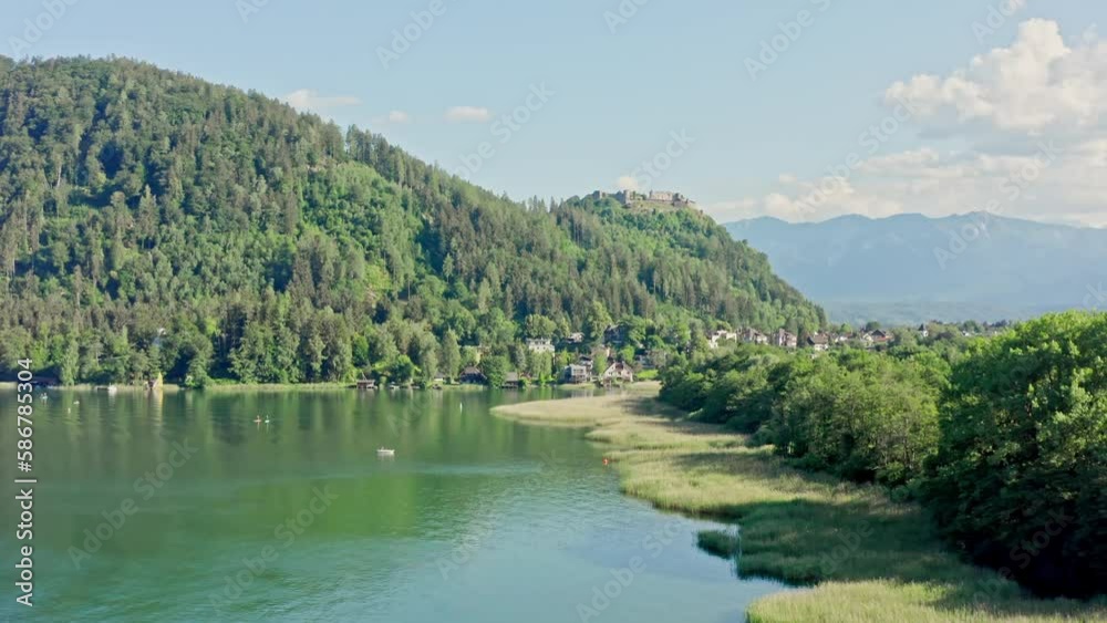 Lake Ossiach is a stunning alpine lake located in the state of Carinthia, Austria, surrounded by the majestic Nock Mountains and offering a range of recreational activities. Aerial view Lake Ossiach is a stunning alpine lake located in the state of Carinthia, Austria, surrounded by the majestic Nock Mountains and offering a range of recreational activities. Aerial view