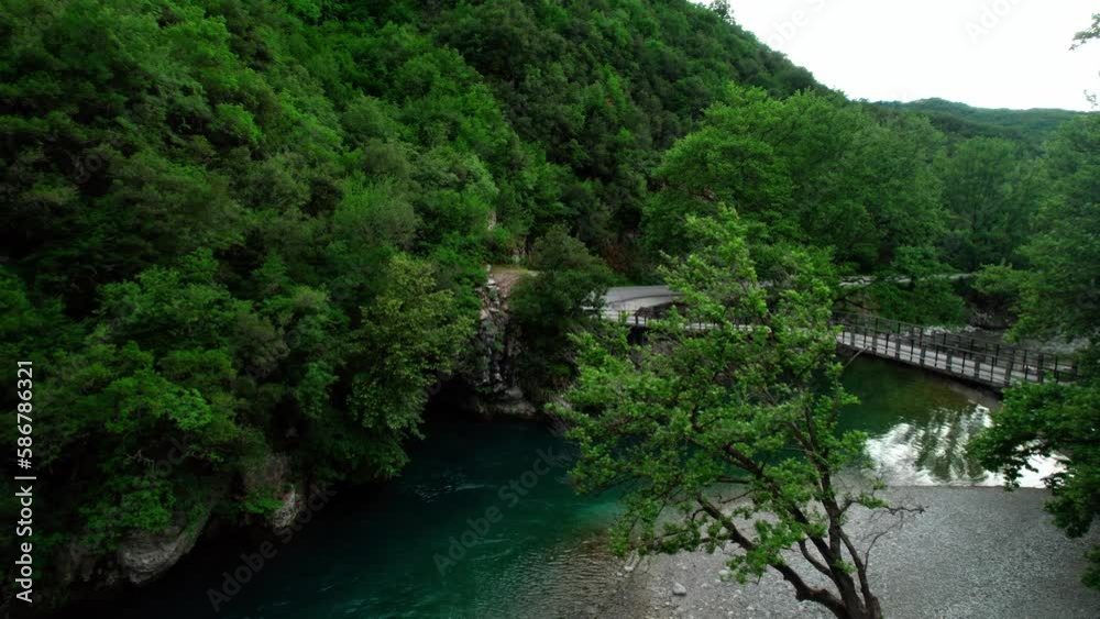 Cinematic aerial dolly in view towards a car crossing a small bridge in a European National Park at daytime Cinematic aerial dolly in view towards a car crossing a small bridge in a European National Park at daytime