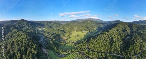 Landscape Panorama view, farmland surrounded by mountains and clear sky.