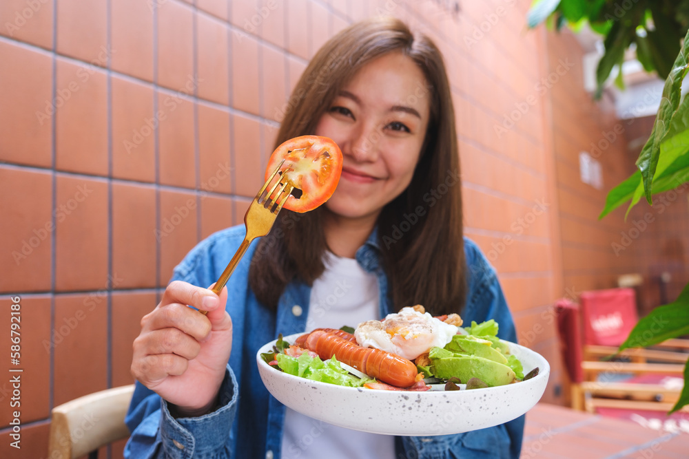 Portrait image of a young woman eating salad Portrait image of a young woman eating salad
