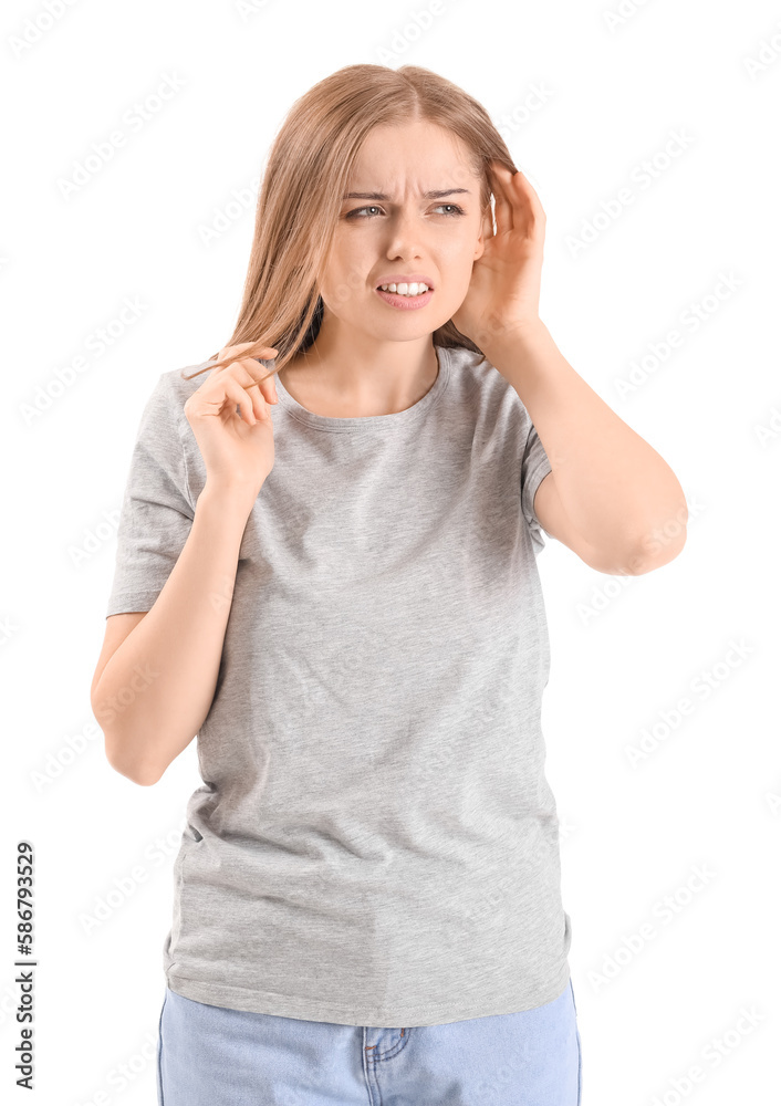 Irritated young woman suffering from loud noise on white background Irritated young woman suffering from loud noise on white background