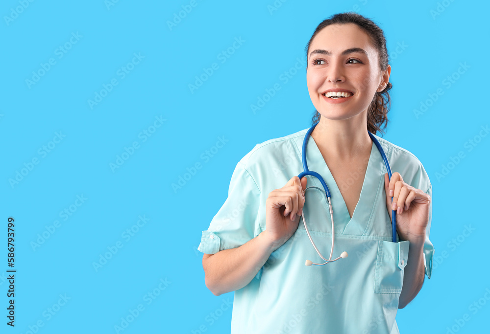 Female medical assistant with stethoscope on light blue background Female medical assistant with stethoscope on light blue background