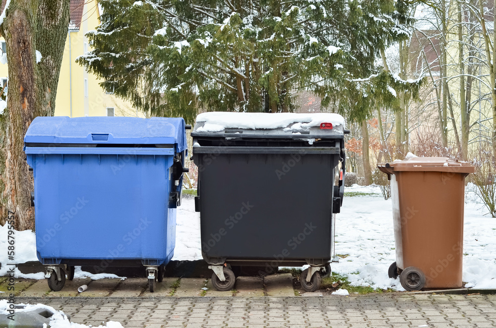View of garbage containers in city on winter day View of garbage containers in city on winter day