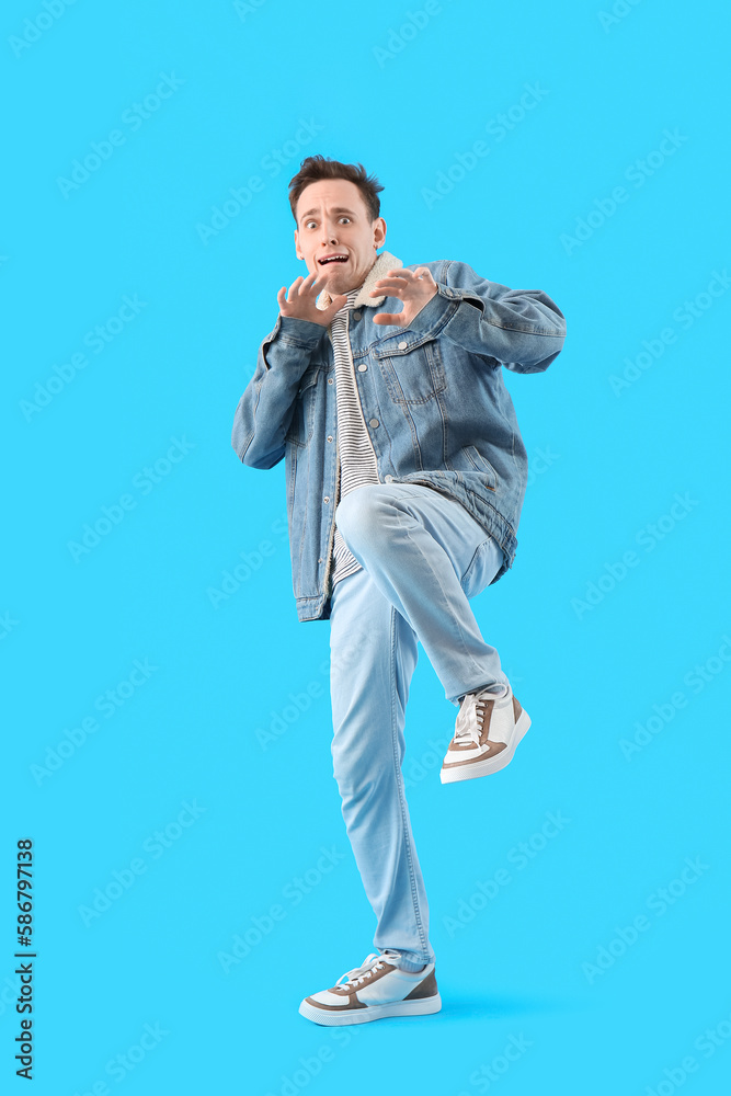 Fototapeta premium Scared young man on light blue background