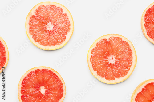 Composition with slices of ripe grapefruit on white background, closeup