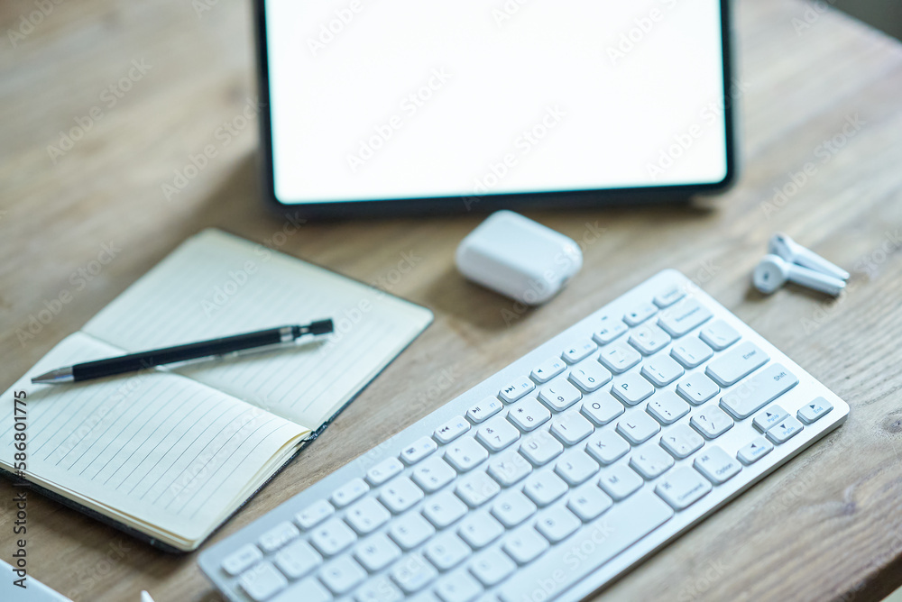 カジュアルなテーブルに置かれたタブレットPCなどビジネス道具一式