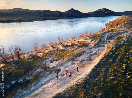 People running at country road near river aerial landscape