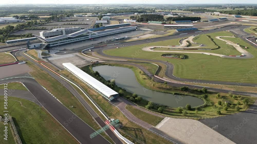 Silverstone international pit straight and lake alongside F1 race track circuit aerial reversing view Silverstone international pit straight and lake alongside F1 race track circuit aerial reversing view