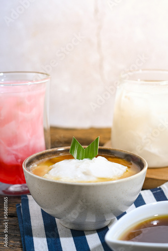 Bubur Sumsum served on wooden table, Javanese dessert porridge of rice flour, coconut milk with brown sugar syrup. A popular iftar food for breaking the fast Ramadan