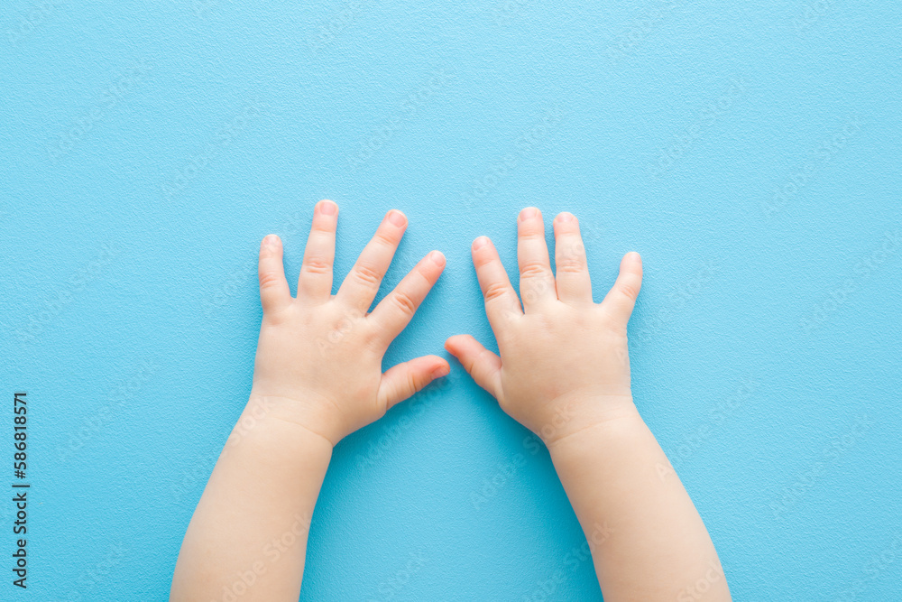 Baby boy hands on light blue table background. Pastel color. Closeup. Point of view shot. Top down view. Baby boy hands on light blue table background. Pastel color. Closeup. Point of view shot. Top down view.