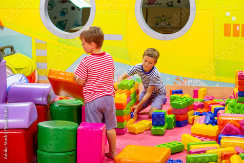 Cute boys playing with building toy colorful blocks. Preschool activities and early childhood education. Kid with happy face playing with plastic bricks. Plastic Large Toy. big cubes bricks