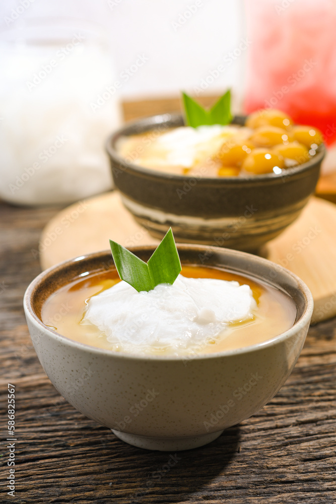 Bubur Sumsum served on wooden table, Javanese dessert porridge of rice flour, coconut milk with brown sugar syrup. A popular iftar food for breaking the fast Ramadan Bubur Sumsum served on wooden table, Javanese dessert porridge of rice flour, coconut milk with brown sugar syrup. A popular iftar food for breaking the fast Ramadan