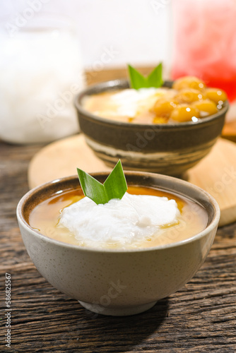 Bubur Sumsum served on wooden table, Javanese dessert porridge of rice flour, coconut milk with brown sugar syrup. A popular iftar food for breaking the fast Ramadan