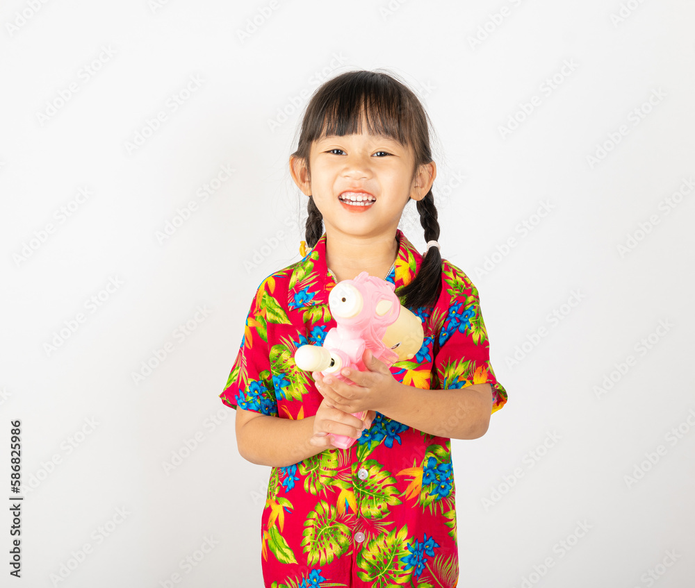 Happy Songkran Day, Asian kid girl with floral shirt hold water gun, Thai child funny hold toy water pistol and smile, isolated on white background, Thailand Songkran festival national culture concept Happy Songkran Day, Asian kid girl with floral shirt hold water gun, Thai child funny hold toy water pistol and smile, isolated on white background, Thailand Songkran festival national culture concept