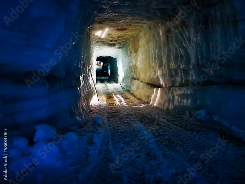 Foto A man-made ice tunnel in Iceland, illuminated with soft lights, reveals tire tra