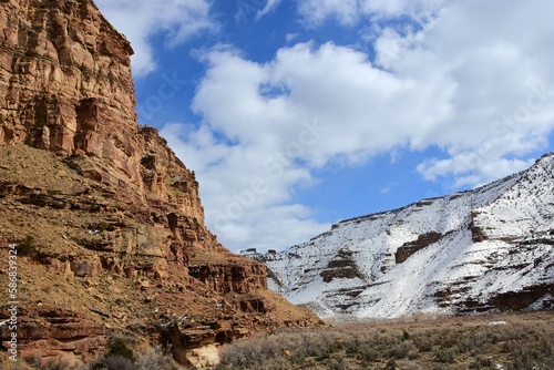 steep sandstone cliffs and snow- covered hillside on a sunny winter day near the ancient native american owl panel petroplyphs in nine mile canyon, near wellington, utah