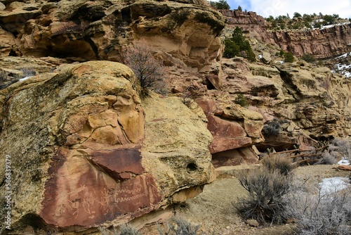 steep sandstone cliffs and  the ancient native american owl panel petroglyphs on a sunny winter day  in nine mile canyon, near wellington, utah photo